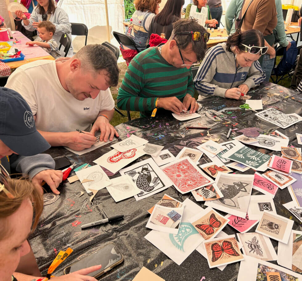 People at a table making lino prints