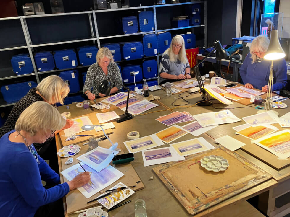 People at a table painting