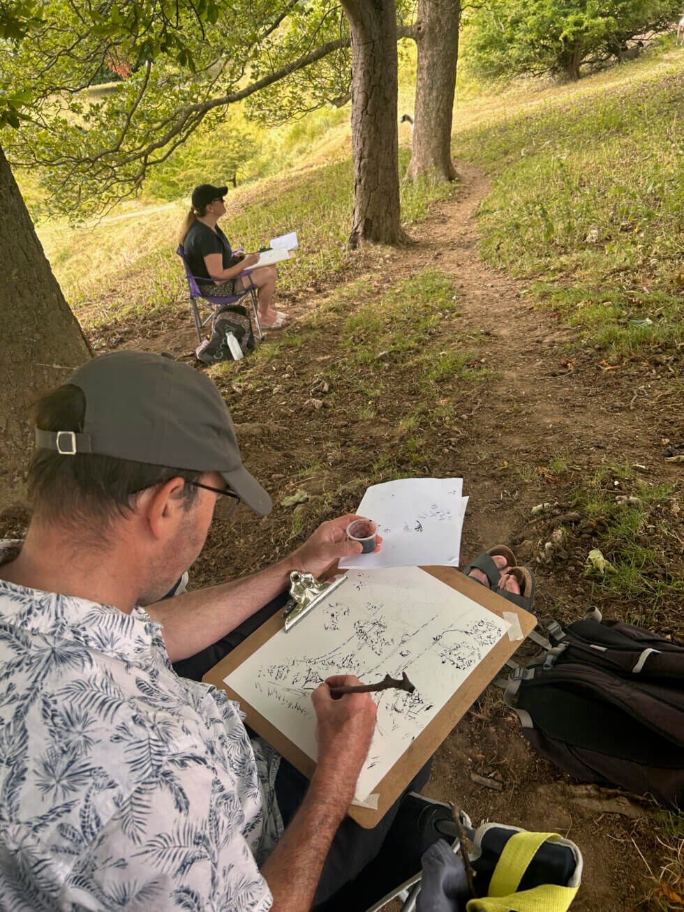 A man outside drawing trees
