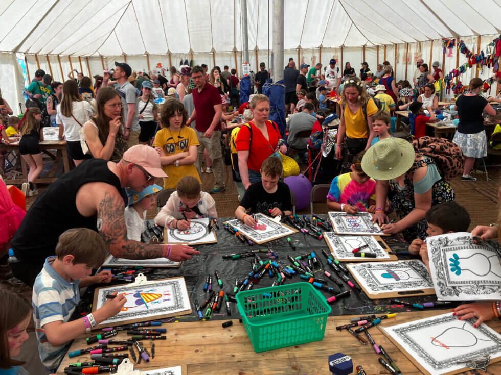 Lots of people inside a marquee drawing
